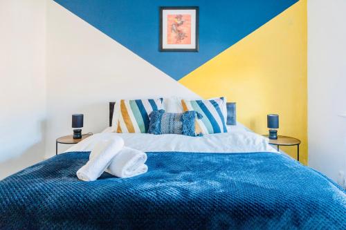 Un dormitorio con una cama azul con toallas. en Comfy 3 Bed House by Manchester Airport, Perfect for Groups & Families, en Mánchester