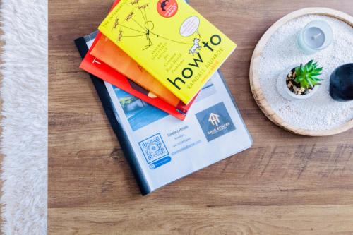 un libro sentado en una mesa junto a un plato en Comfy 3 Bed House by Manchester Airport, Perfect for Groups & Families, en Mánchester