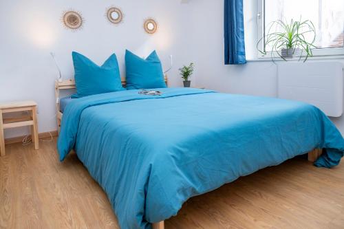- un lit bleu avec des draps bleus dans une chambre dans l'établissement Le Bretzel Petite Venise Vieille Ville City Center Wi-Fi, à Colmar