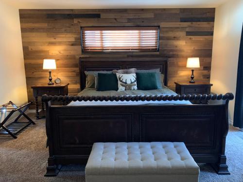 a bedroom with a large bed with a wooden wall at TimberWood Cabin- 3 Bdr - 2 Bth - Big Game room - Prime Location in Big Bear Lake in Big Bear Lake