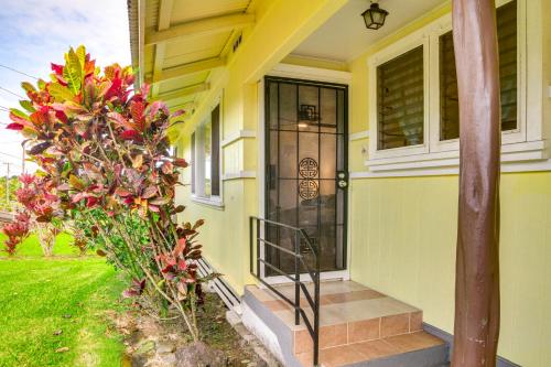 a yellow house with a front door and a plant at Charming Historic Hilo House Minutes to Beach! in Hilo
