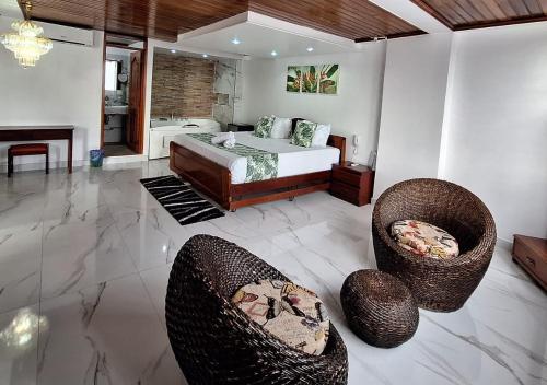 a bedroom with a bed and two chairs at Hotel Yurupary AMAZONAS in Leticia