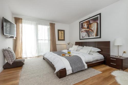 um quarto com uma cama grande e uma janela grande em VIlla Laetitia em Žrnovnica