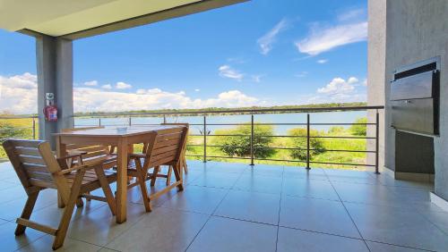 a dining room with a table and chairs on a balcony at Sandpiper Villas Chobe in Kasane