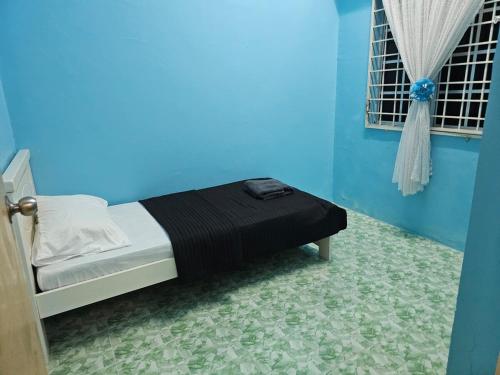 a blue bedroom with a bed in a room at Mumtaz Beach Homestay in Dungun