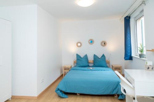 - une chambre avec un lit bleu et un bureau dans l'établissement Le Bretzel Petite Venise Vieille Ville City Center Wi-Fi, à Colmar