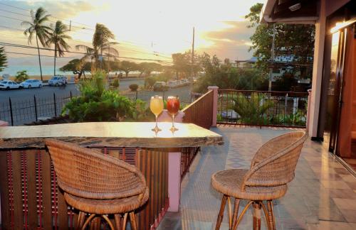 a table with two wine glasses on a balcony at Terraza Suite Frente al Mar in Puntarenas