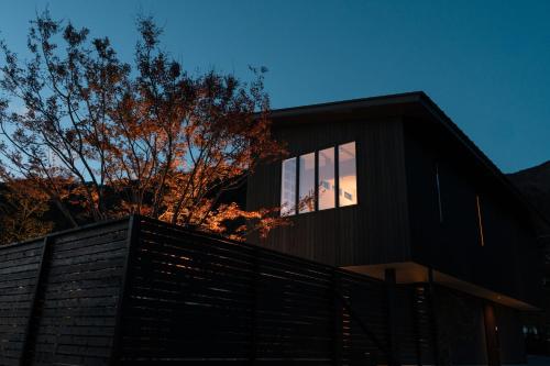 a black house with a fence in front of it at 富士山望むプライベートヴィラ 900平方メートルの敷地を貸切利用 憩 ikoi Fuji サウナ 4Kシアター in Fujikawaguchiko