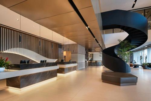 a lobby with a spiral staircase in a building at Residence Inn by Marriott Santiago de los Caballeros in Santiago de los Caballeros