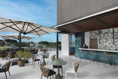 an outdoor patio with tables and chairs and a bar at Residence Inn by Marriott Santiago de los Caballeros in Santiago de los Caballeros