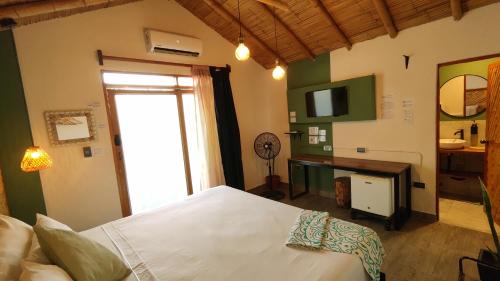 a bedroom with a white bed and a television at Puerto Bamboo in Máncora