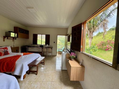 a bedroom with a bed and a large window at Flat HOTEL Pedra do Rodeadouro 1 andar in Bonito