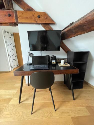 a desk with a laptop and a computer monitor on it at Les Chambres d'Orsay in Orsay