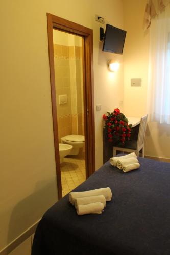 a room with a bed with two towels on it at Hotel Senyor in Rimini