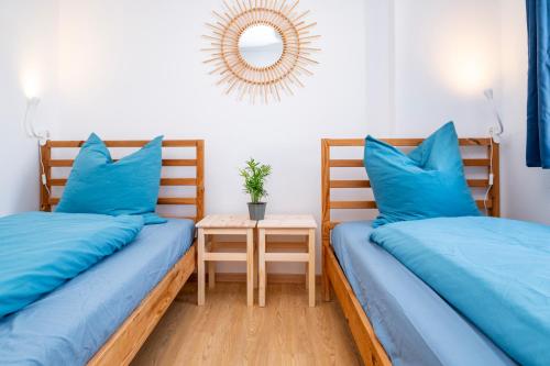 - 2 lits dans une chambre avec des oreillers bleus et une table dans l'établissement Bretzel Twin Petite Venise Vieille Ville City Center Wi-Fi, à Colmar