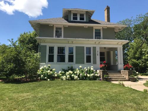 a house with white flowers in the yard at CRAFTSMAN UPSTAIRS with impressive attic! in Willmar