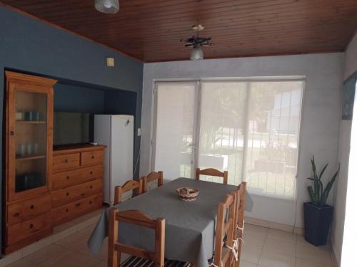a dining room with a table and chairs and a window at Lo de Marito in Balneario Claromecó