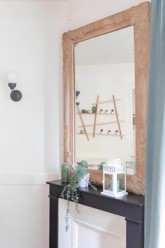 un miroir au-dessus d'une commode dans une pièce dans l'établissement Cozy near Paris - La Défense, à Suresnes