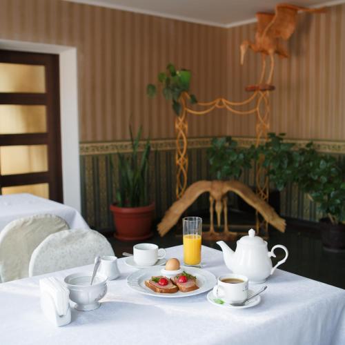 a table with a plate of food and cups of coffee at Britaniya in Kharkiv