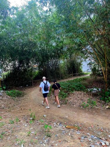 two people walking down a dirt road at Blue Tropical House Hội An in Hoi An