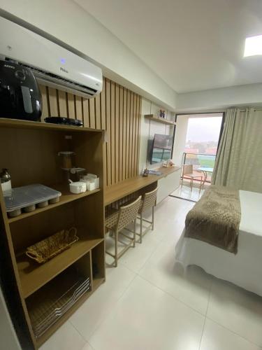 a bedroom with a bed and a desk in a room at Makani Flat Campas in Tamandaré