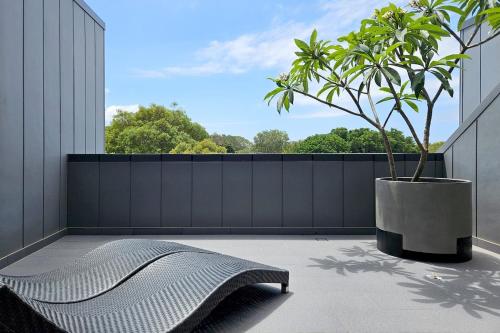 a bench sitting on a balcony with a potted plant at Family-Friendly 3 Levels Architect Home Near Airport Beach Sydney City FREE City Parking & Airport Pickup Available in Sydney