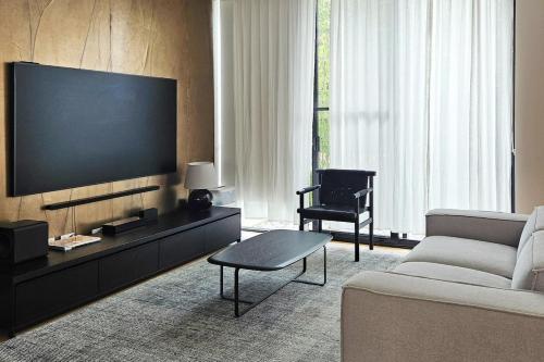 a living room with a couch and a flat screen tv at Family-Friendly 3 Levels Architect Home Near Airport Beach Sydney City FREE City Parking & Airport Pickup Available in Sydney