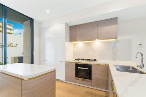 a kitchen with a sink and a stove at Family-Friendly 3 Levels Architect Home Near Airport Beach Sydney City FREE City Parking & Airport Pickup Available in Sydney