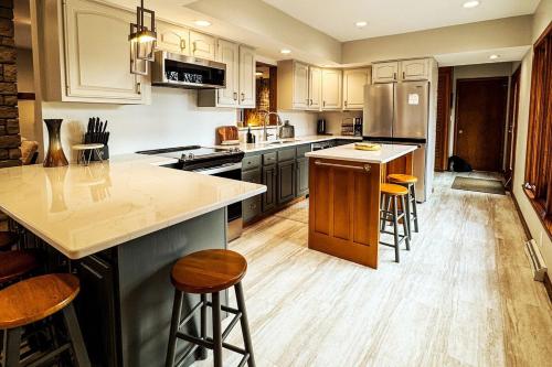 a kitchen with wooden floors and a large island with bar stools at MI CASA- 4 Bd- Mega Playground in Willmar