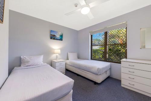 a bedroom with two beds and a window at Kalua Holiday Apartments in Maroochydore