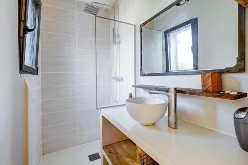 ein Badezimmer mit Waschbecken und Spiegel in der Unterkunft A Stalla - Maison pieds dans l'eau à Lucciana in Lucciana