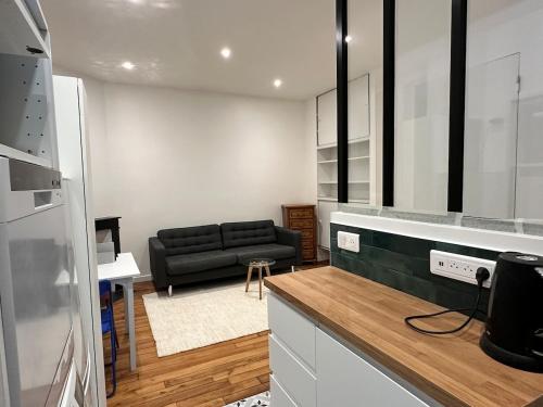 - une cuisine avec un canapé noir dans le salon dans l'établissement Casa Preciosa, à Ivry-sur-Seine
