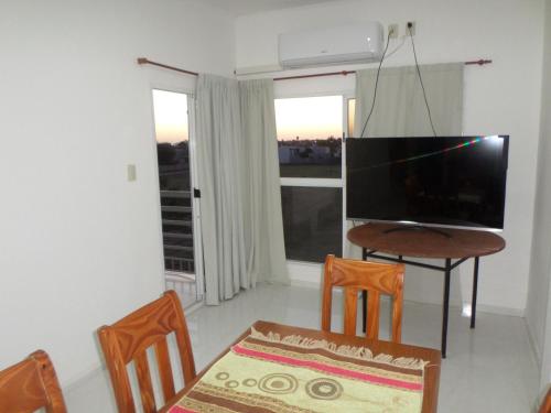 a living room with a television and a table and chairs at EL JACARANDÁ in Charata