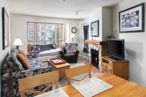 a living room with a couch and a fireplace at Town Plaza Suites by Golden Dreams in Whistler