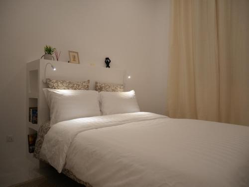 un lit blanc avec des draps et des oreillers blancs dans l'établissement Appart cosy Paris Bercy, à Paris