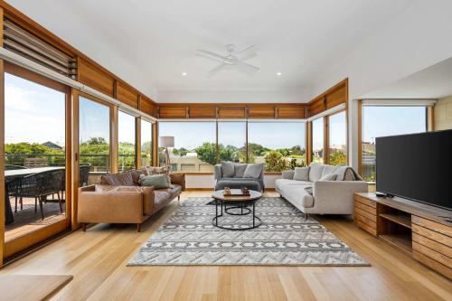 a living room filled with furniture and a flat screen tv at Ocean Breeze - Retreat in Torquay Sleeps 11 in Torquay