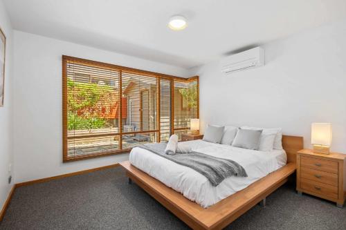 a bedroom with a large bed and a window at Ocean Breeze - Retreat in Torquay Sleeps 11 in Torquay