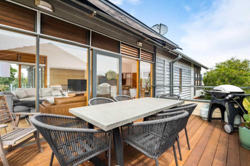 a patio with a table and chairs on a deck at Ocean Breeze - Retreat in Torquay Sleeps 11 in Torquay