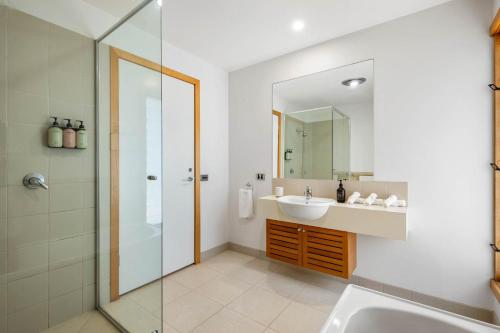 a bathroom with a sink and a shower and a mirror at Ocean Breeze - Retreat in Torquay Sleeps 11 in Torquay