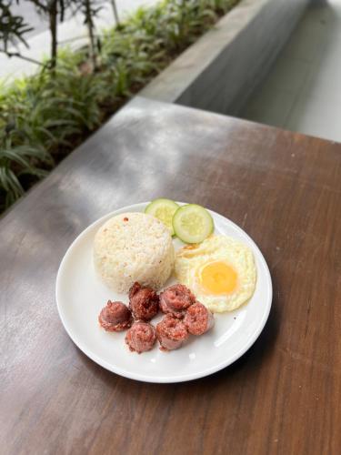 a white plate with eggs and meatballs on a table at 1075 Dormitel in Cebu City