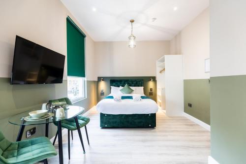 a bedroom with a bed and a table and a tv at The Chapter Hotels - Finsbury Park in London