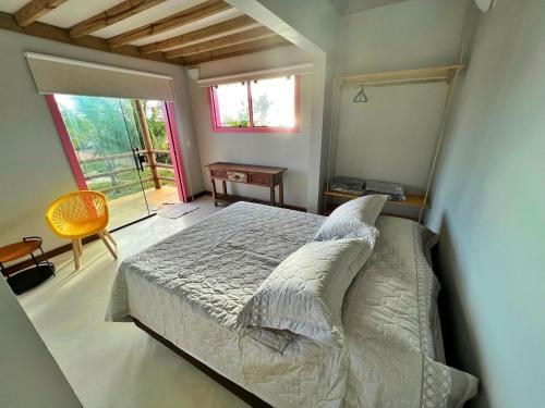 Un dormitorio con una cama y una ventana grande. en Cara,Viva Flats, en Porto Seguro