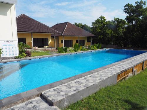 a swimming pool in front of a house at Scuba Tribe Bali dive-resort in Tulamben