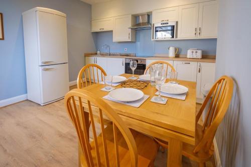 a kitchen with a wooden table with chairs and a dining room at Teviot Cottage - Gorgeous Cosy & Modern 2BR Cottage in Hawick in Hawick