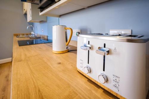 a kitchen with a stove top on a wooden floor at Teviot Cottage - Gorgeous Cosy & Modern 2BR Cottage in Hawick in Hawick
