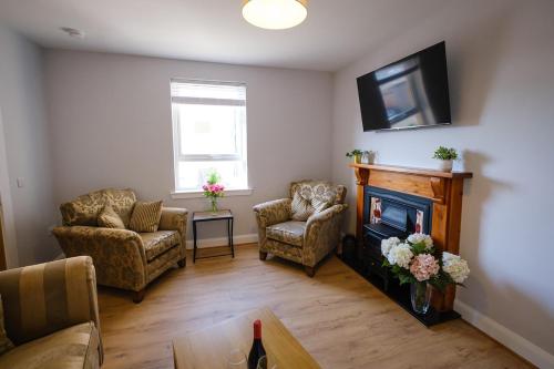 a living room with a fireplace and a tv at Teviot Cottage - Gorgeous Cosy & Modern 2BR Cottage in Hawick in Hawick