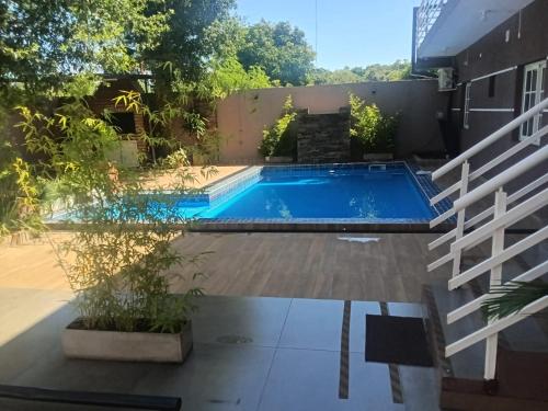 a swimming pool in the backyard of a house at Apart Encanto Iguazú in Puerto Iguazú
