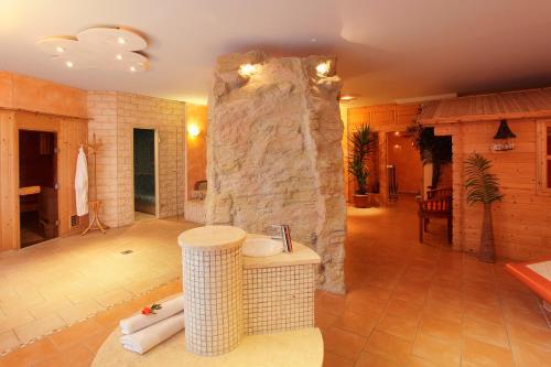 a large living room with a large stone wall at Land- und Aktivhotel Altmühlaue in Bad Rodach