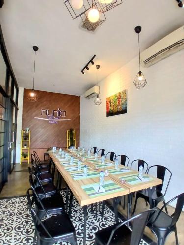 a conference room with a long table and chairs at Nunia Tamansari Hotel in Kumprung