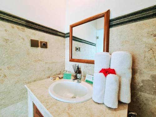 a bathroom with a sink with towels on the counter at Sejati Villas - Petitenget in Seminyak